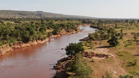 Maasai-Mara-River-Aerial-drone-shot-of-Beautiful-Landscape-Scenery-in-Africa,-Masai-Mara-in-Kenya-Establishing-Wide-View-From-High-Up-Above-with-Trees-Greenery-and-Lush-Green-Scene