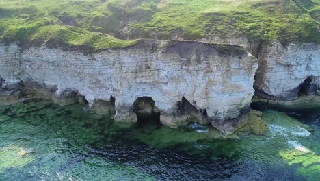 beautiful chalk coastal cliffs at low tide, with visible cracks showing in the cliff faces