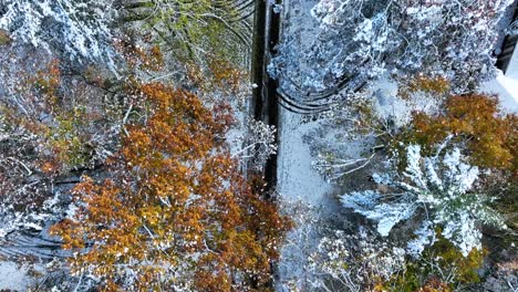 a direct aerial tracking over snowy roads in autumn