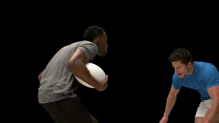 Serious rugby players tackling for ball