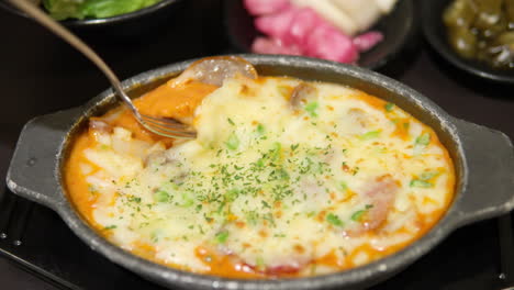 recogiendo el gratin de patata con queso rosa con un tenedor - cámara lenta de primer plano