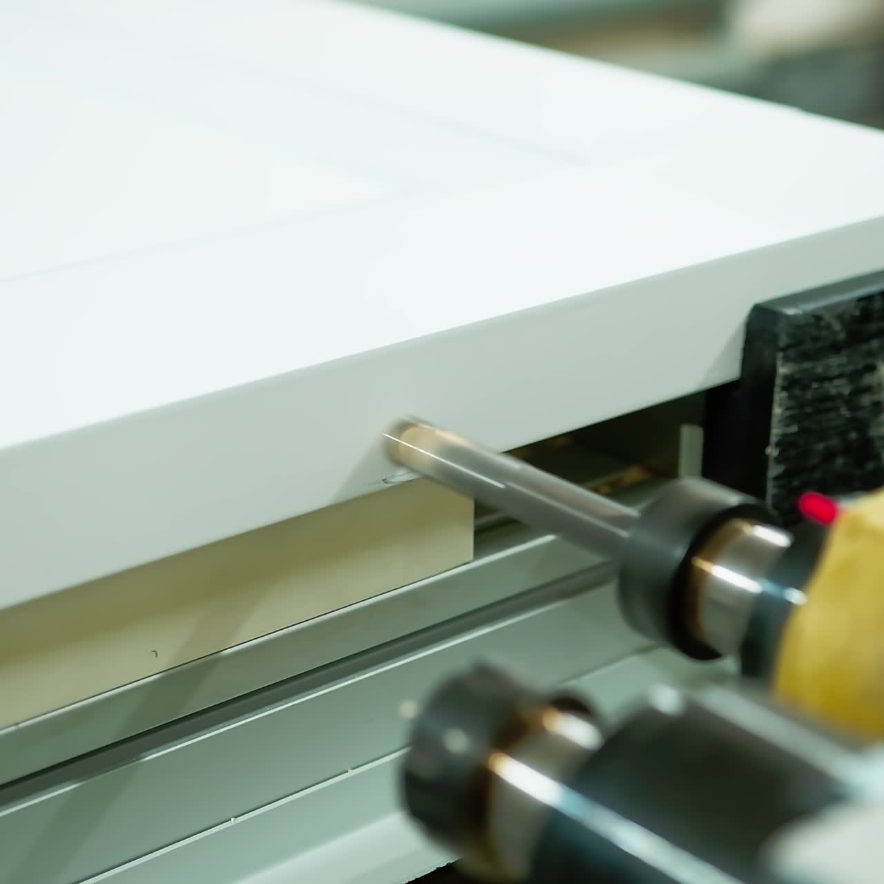 Furniture production. Modern machine tool for making doors. Industrial equipment making hole in wooden board. Close-up.