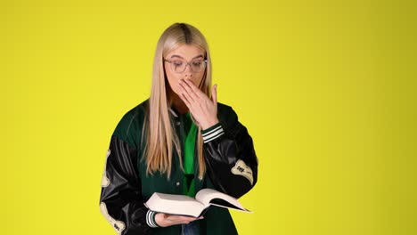 Blonde-Student-Reading-a-Book-Then-Surprised-Astonished-Face-Expression,-Colorful-Studio-Shot