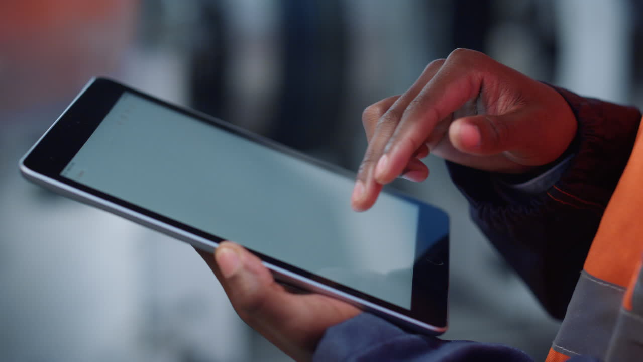 알려지지 않은 남자의 손이 현대 공장에서 태블릿 컴퓨터 디지털 화면을 누르고 있습니다.