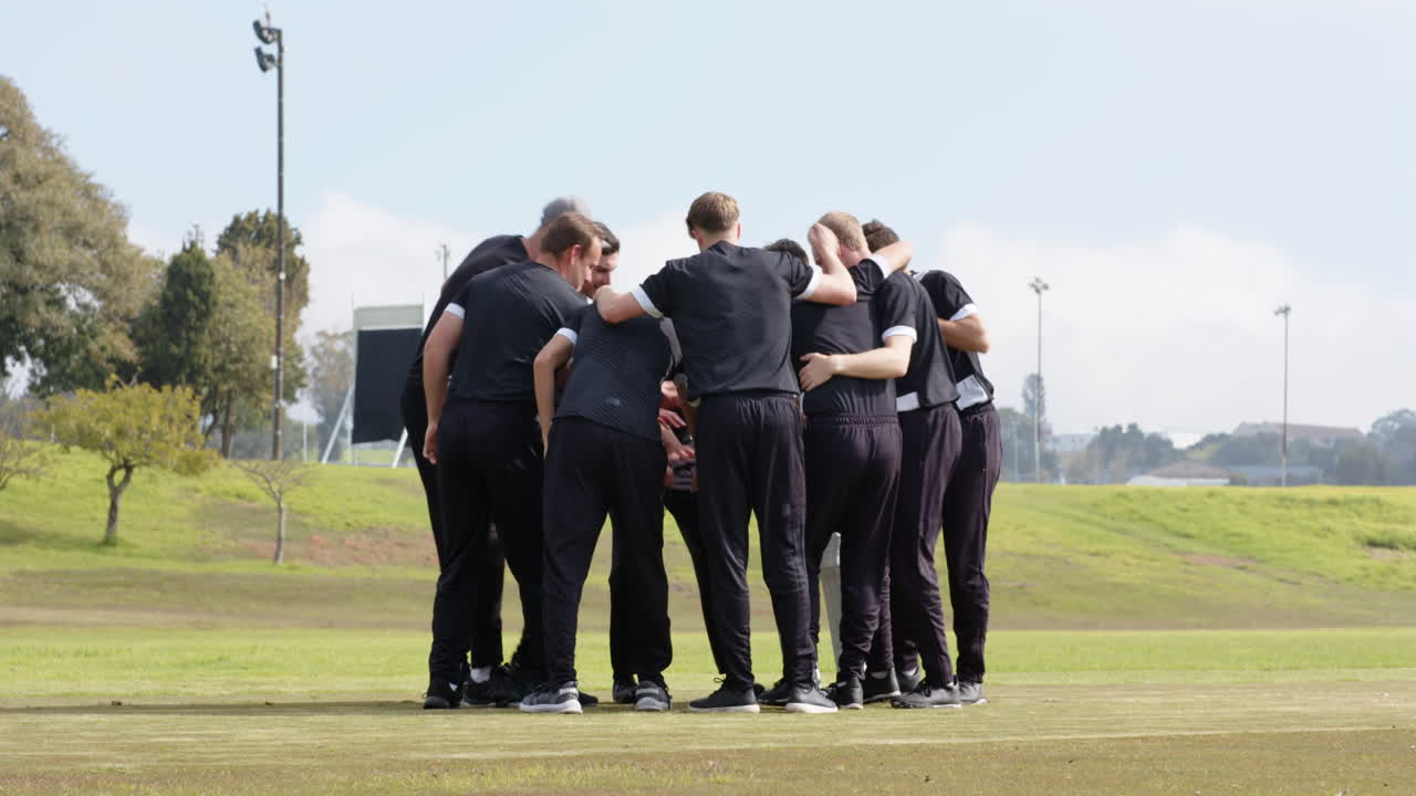 Squadra di cricket caucasica che si riunisce sul campo, preparando la strategia per la partita.