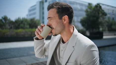 man drinking coffee at sunny square closeup. businessman enjoying lunch