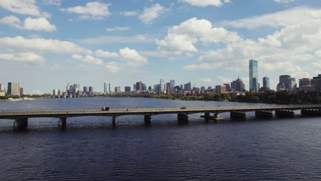 boston city skyline, people and cars travelling on harvard bridge