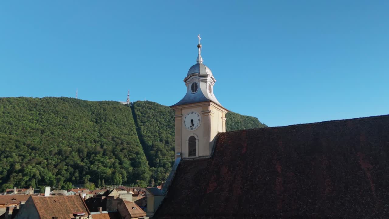 Clock tower with scenic hills in background on a sunny day