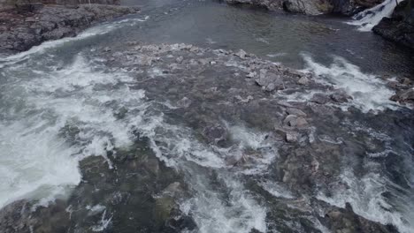 a large, mountain, rushing river flowing between rocks, aerial view