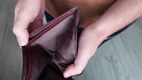 the man checks his wallet but there is no money in it