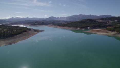 lake with calm waters and the sky reflected in it. mirror effect. aerial view of a beautiful lake surrounded by mountains. sky and clouds reflected in the lake waters. granada. spain