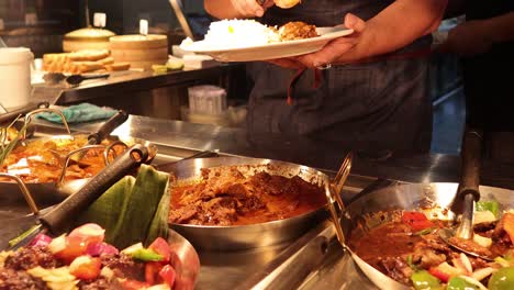 person serving malaysian food at market stall