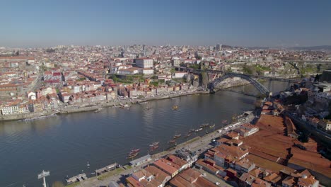 Órbita-Aérea-Con-Un-Impresionante-Panorama-Del-Casco-Antiguo-De-Oporto-Con-El-Puente-Ponte-Dom-Luís-I-Sobre-El-Río-Duero.