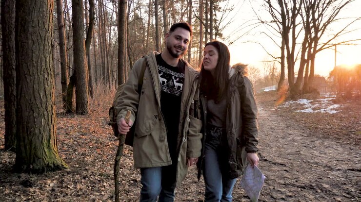 Un couple caucasien en randonnée en forêt.