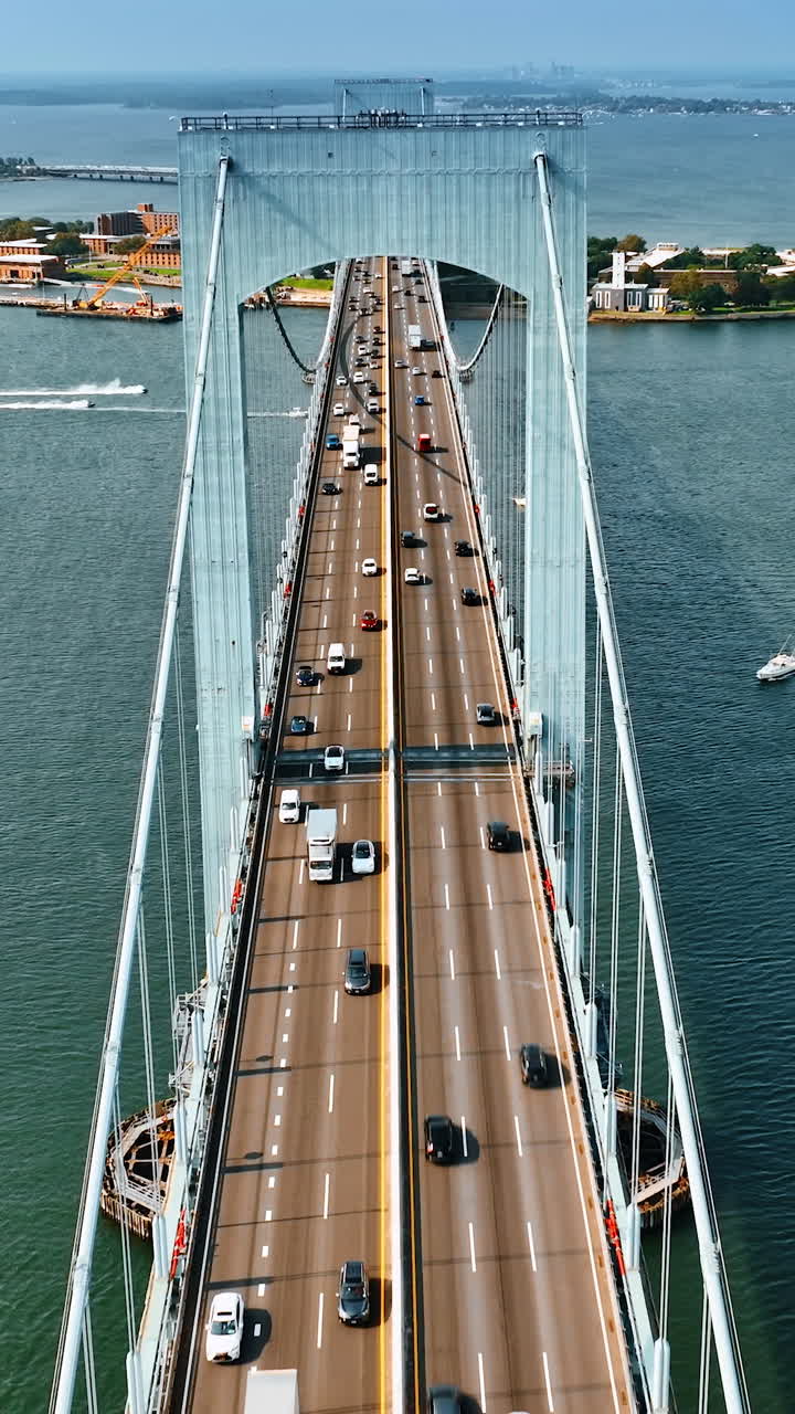 Footage above the bridge along the roads with cars. Many boats on the water. Top view. Vertical video