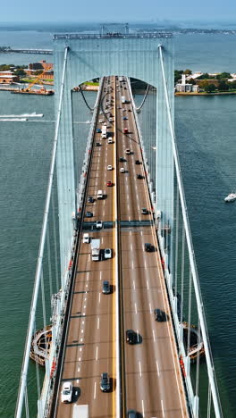 footage above the bridge along the roads with cars. many boats on the water. top view. vertical video