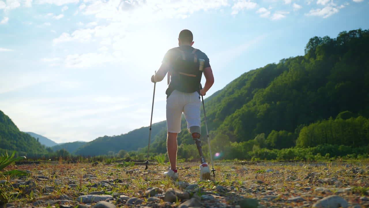 hombre con pierna protésica caminando por las montañas