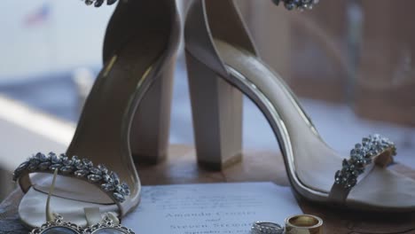 wedding day details: bridal shoes, rings, and invitation