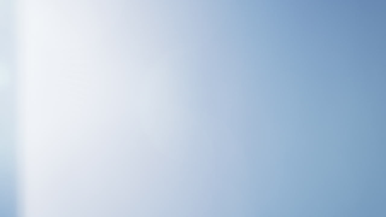 Soft blue lens flare with a gentle light gradient across a clear black background. Ideal for overlays, transitions, visual effects, or adding atmosphere to creative projects