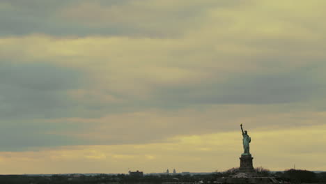 pastel-colored sky over new york harbor and statue of liberty