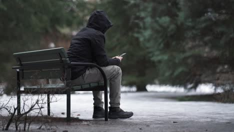 Mann-Sitzt-Auf-Einer-Bank-Und-Benutzt-Sein-Telefon