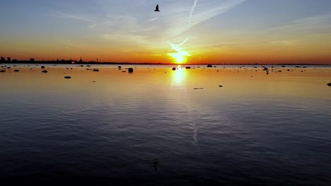 Tallin-Estonia-Pintoresca-Puesta-De-Sol-Sobre-El-Mar-Báltico-Con-Roca-De-Piedra-En-El-Agua-Y-El-Horizonte-De-La-Ciudad-Capital-A-Distancia-Imágenes-Aéreas