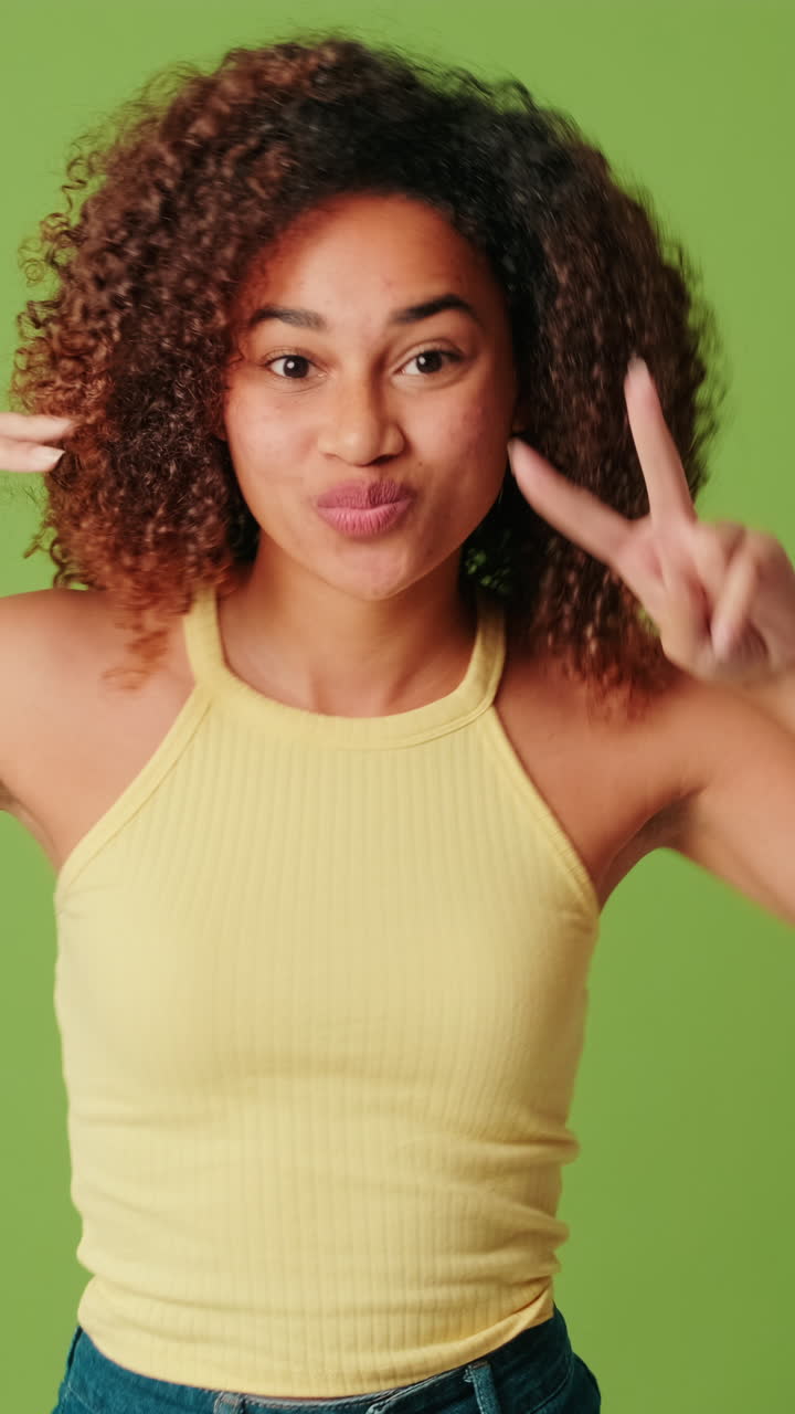 Jovem Mulher Alegre com Cabelo Cacheado Dançando em Tela Verde