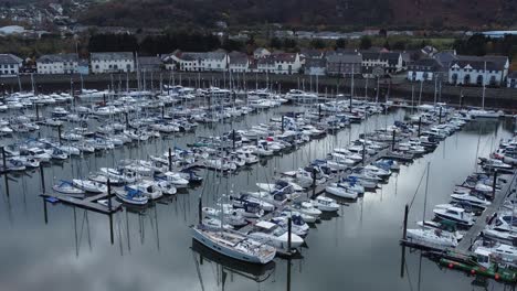 Malerisches-Luxuriöses-Hafenapartmentdorf-Am-Wasser-Yachten-Und-Segelboote-Unter-Der-Luftaufnahme-Der-Bergküste-Vergrößern-Sich