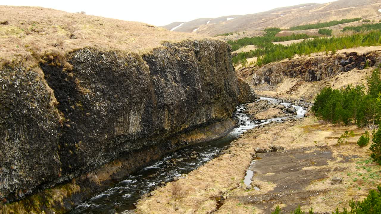 vista aérea sobre un río salvaje y una cascada en un hermoso paisaje - islandia