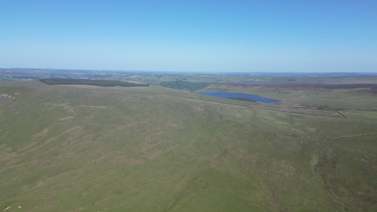 muy alta toma de barrido del verde exuberante campo inglés , con bosques y lagos justo en las cumbres de las colinas , hermosos cielos azules y colinas verdes exuberantes