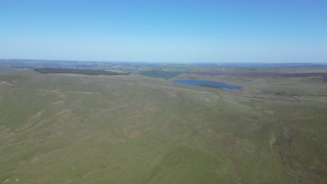 très haute prise de vue de la campagne anglaise verdoyante , avec des forêts et des lacs au sommet des collines , de beaux cieux bleus et des collines verdoyantes