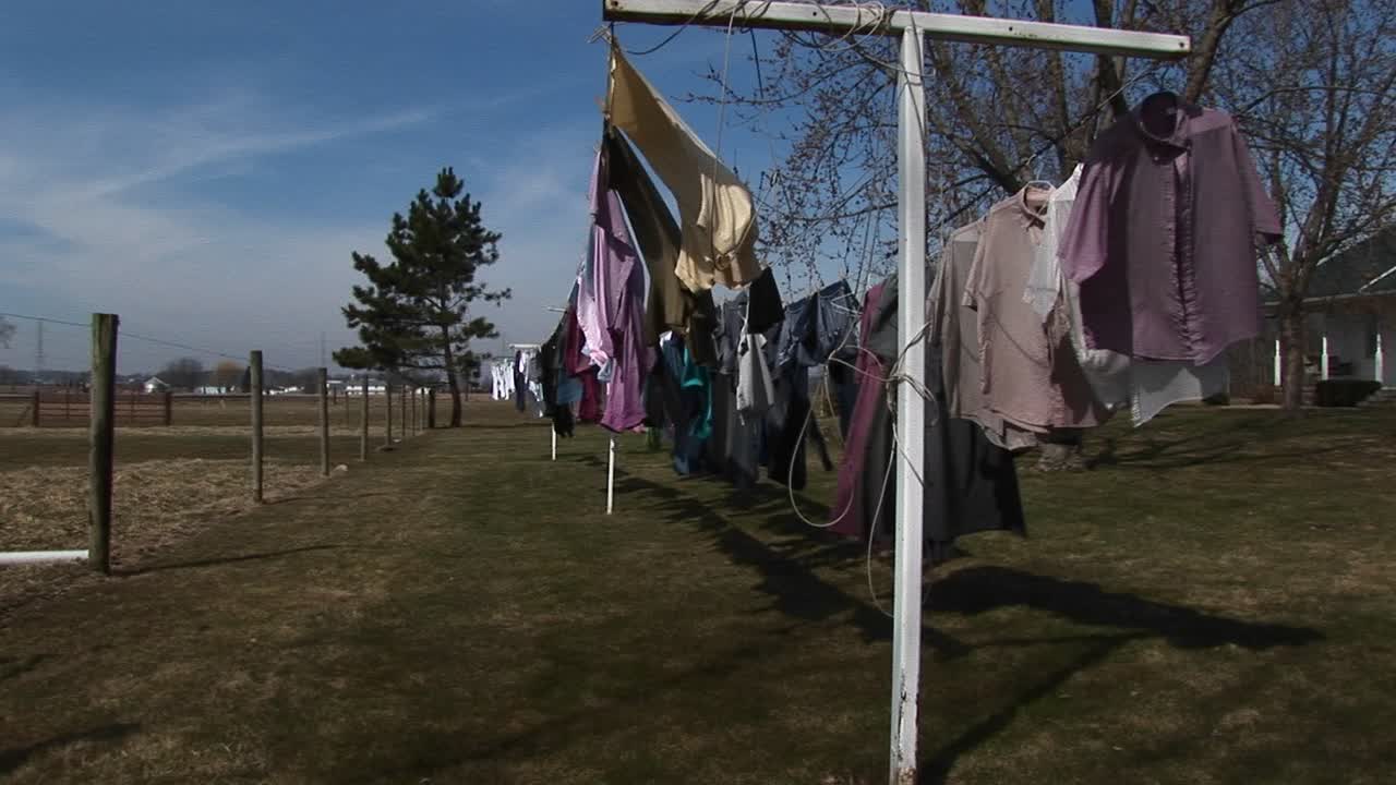 다채로운 세탁물은 시골 지역 사회에서 말리기 위해 야외에 매달려 있습니다.