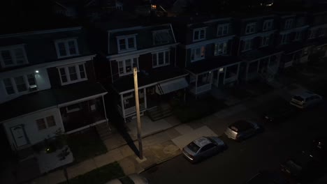 Aerial-night-view-of-a-quiet-residential-street-with-row-houses-and-parked-cars