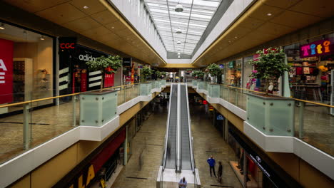 time lapse footage of indoor shopping centre environment with people walking by in žilina aupark, slovakia.