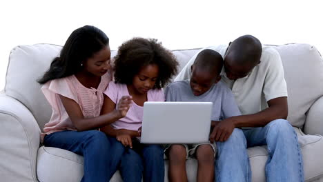 Familia-Con-Laptop-En-Un-Sofá