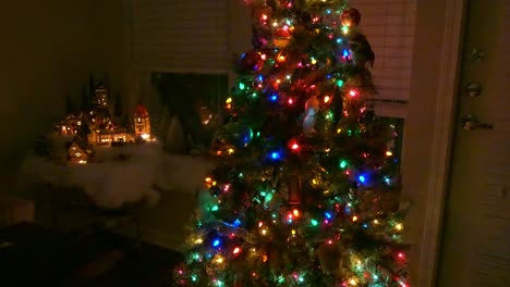 A-model-village-at-Christmas-time-with-Christmas-lights-and-tree-next-to-it-at-night