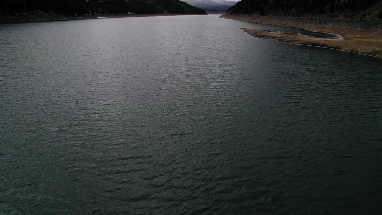 vista aérea de drones volando sobre un cuerpo de agua oscuro y cambiante durante un día nublado con una luz espectacular cerca del embalse dillon de sapphire point colorado