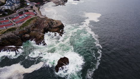 drone tilt-up reveal over gearings point of rocky coastline of hermanus and its historic old harbour, cape whale coast, south africa