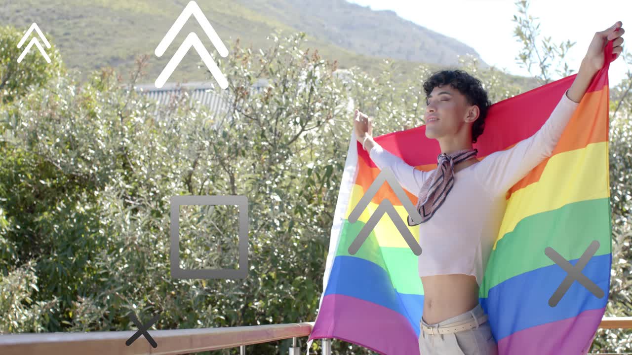 Male raising arms, spreading rainbow flag on balcony while shapes drifting over subject for design