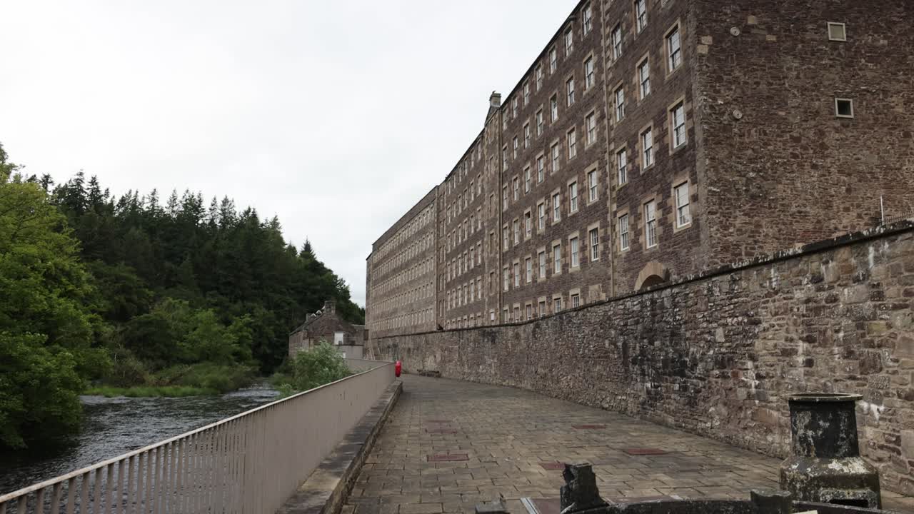 Panning shot revealing old buildings on show at New Lanark, Scotland