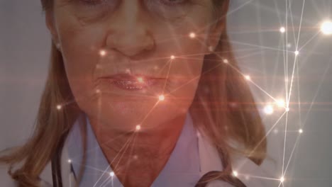 Animation-of-digital-illuminated-dots-connecting-over-smiling-caucasian-senior-female-doctor