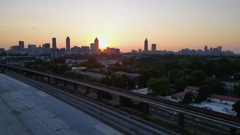 sunset flyover of hulsey rail yard with atlanta city skyline beyond