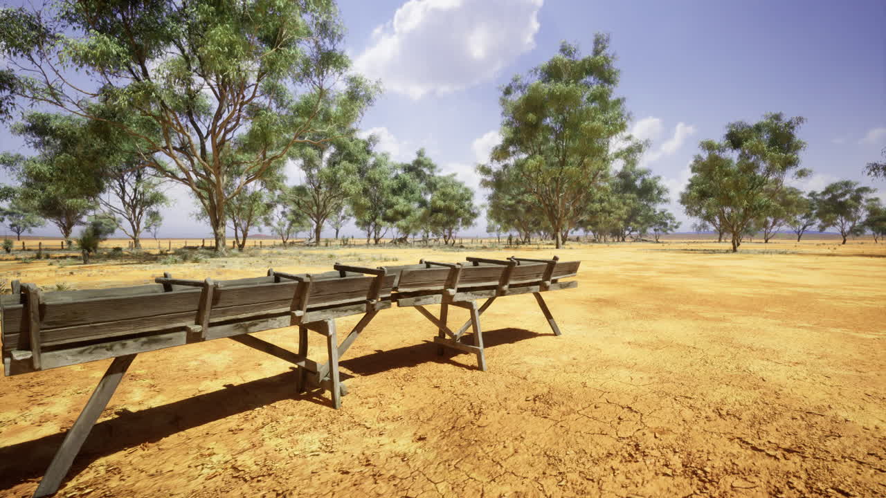 Open landscape with dry terrain and a wooden structure under clear sky