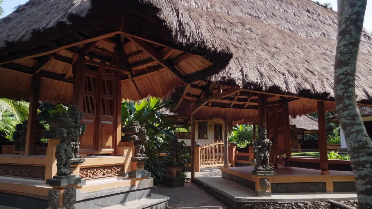 Lush tropical vegetation surrounds a tranquil retreat with a traditional hut featuring a thatched roof, creating a serene and inviting atmosphere