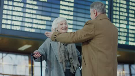 un couple de personnes âgées s'embrasse dans une rencontre émotionnelle à l'aéroport après ne pas s'être vu pendant longtemps