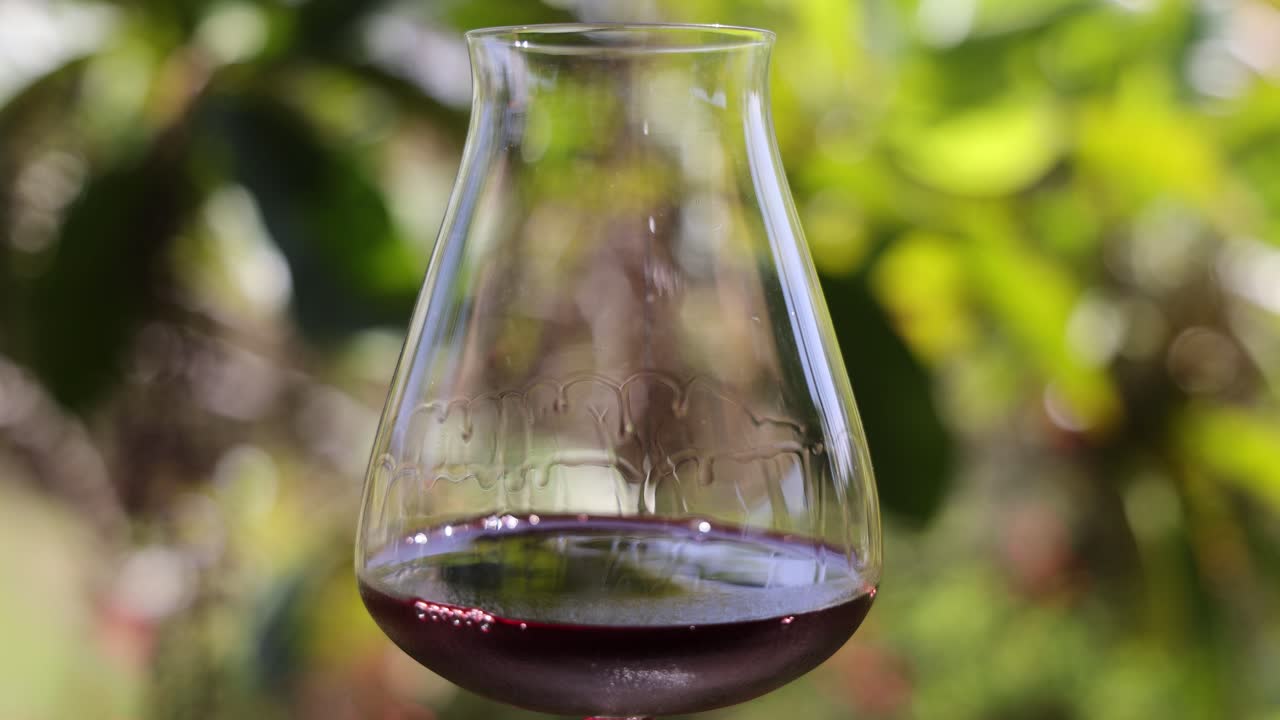 바에 있는 유리 잔에 와인이 부드럽게 회전하고 있습니다.