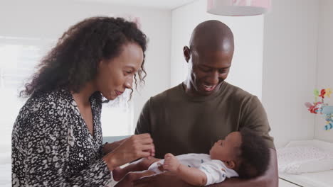 loving parents standing in nursery at home cuddling baby son
