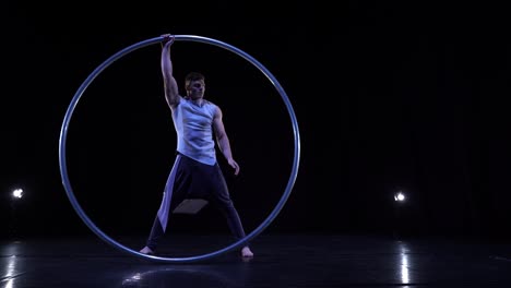 artista de circo muestra concentración y equilibrio mientras gira en una rueda de circo