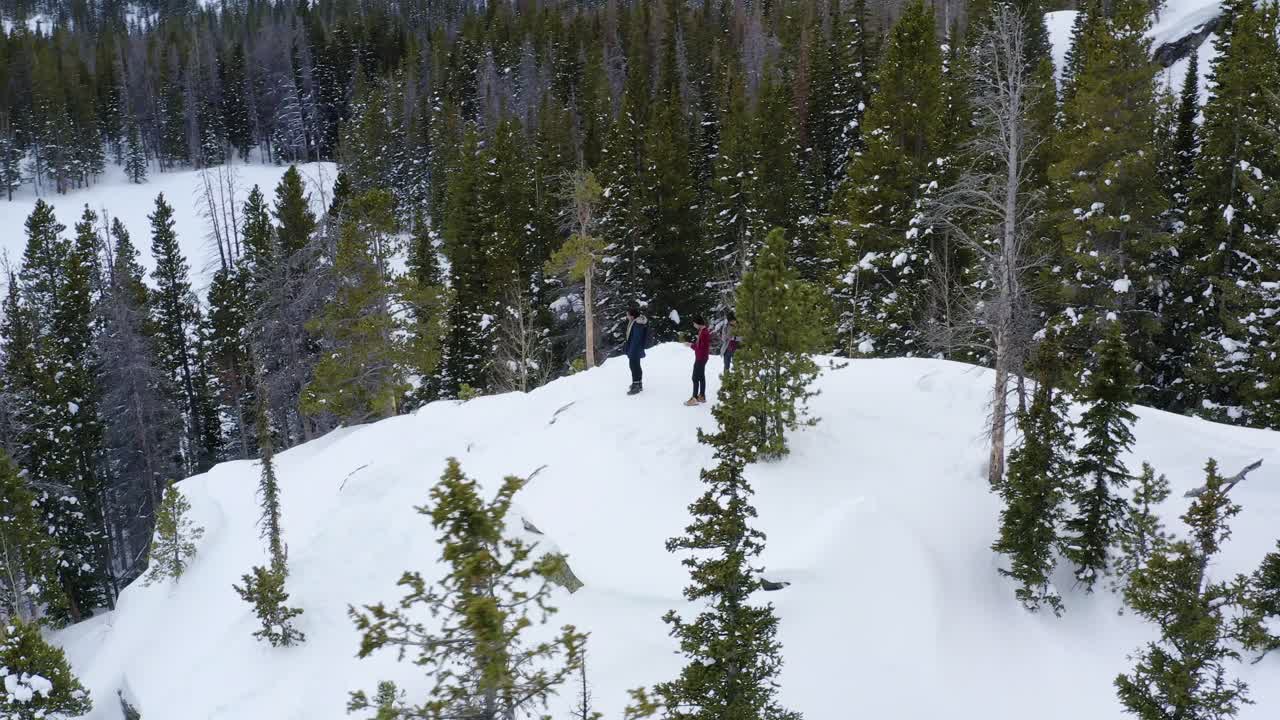 toma aérea en órbita de un grupo de personas en una montaña nevada