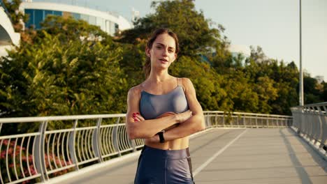 Portrait-of-a-girl-in-a-sports-summer-uniform-after-jogging-in-the-morning.-Athletic-girl-posing-and-looking-at-the-camera-with-her-arms-folded-across-her-chest